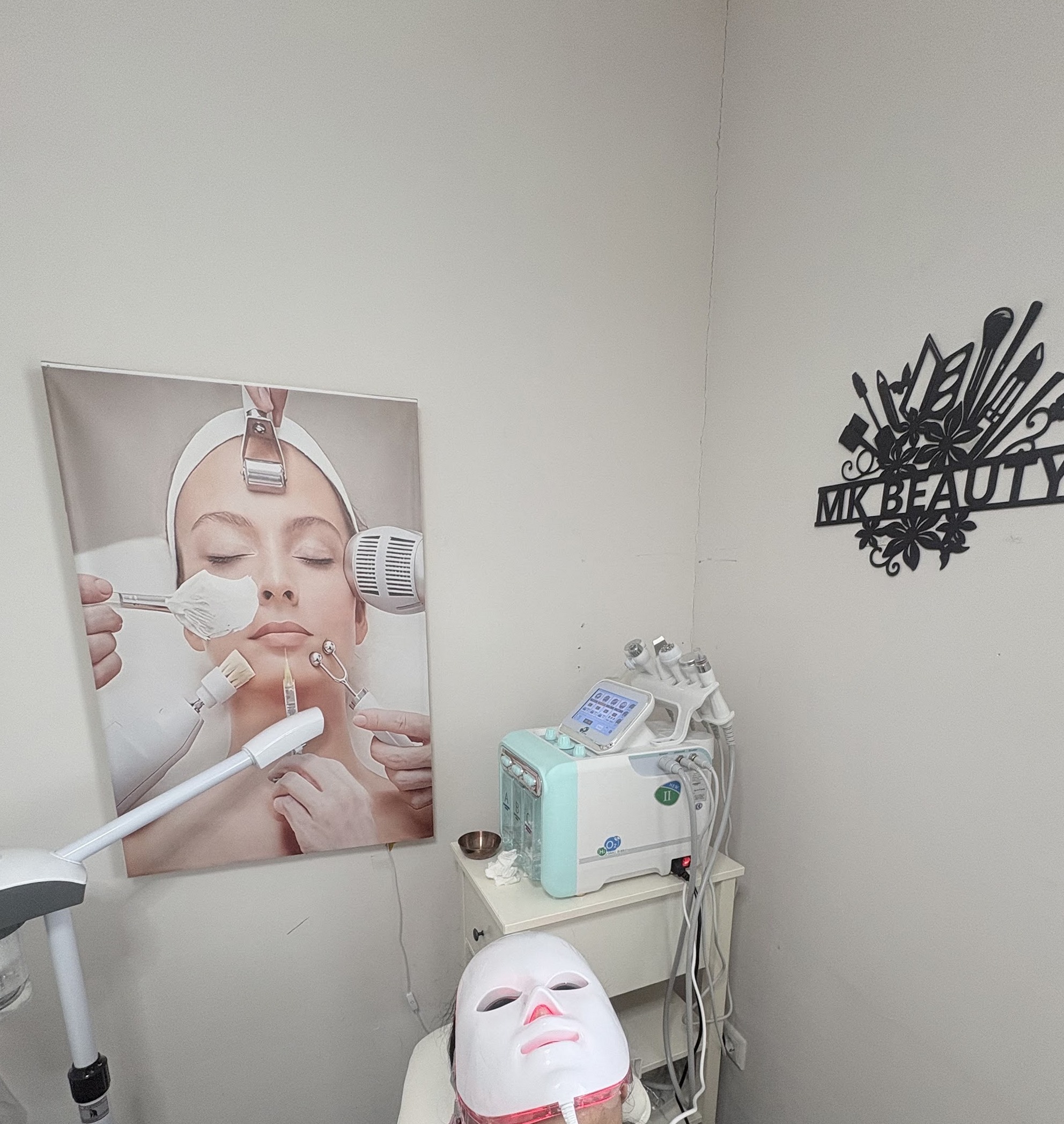 Behandelhoek met de hydrafacial-machine, een LED-masker en het zwarte MK BEAUTY wandbord